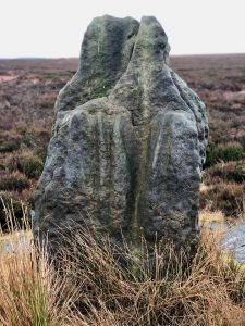 Portrait photo of the weatherworn sandstone standing stone known as 'Blue Man-i'-th'-Moss'