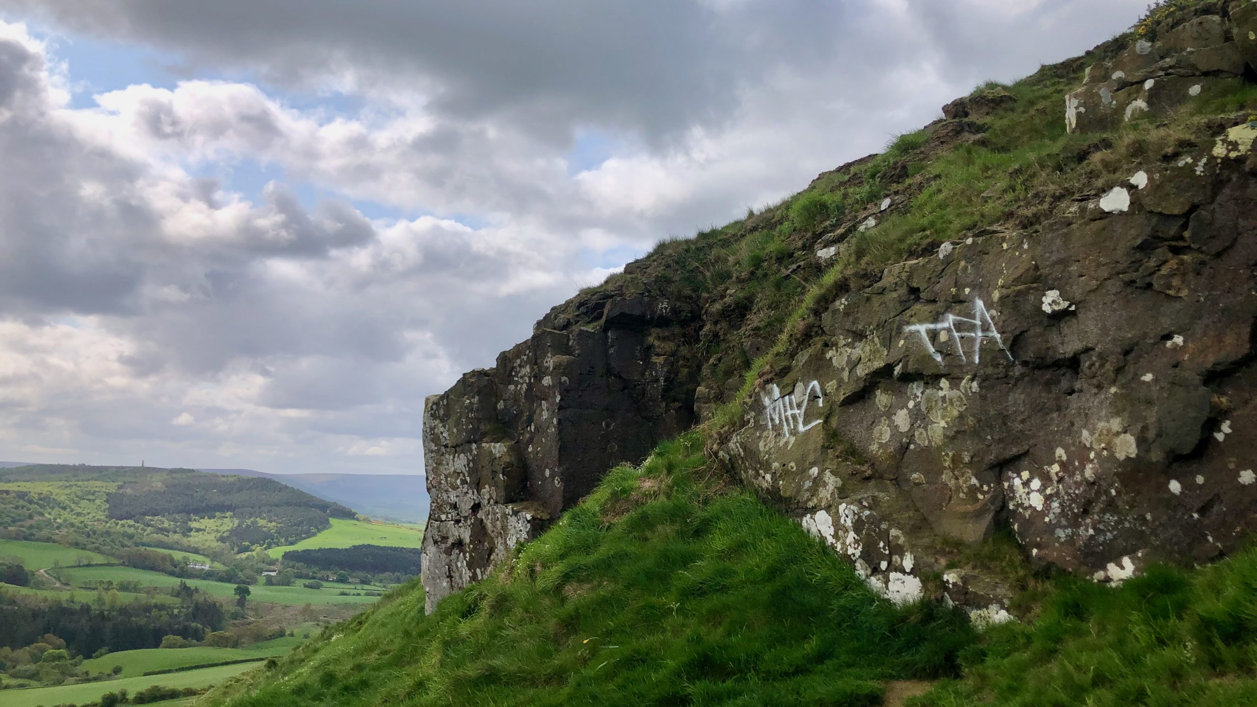 A thought-provoking piece of artwork that juxtaposes the simplicity of an alphabetical motif with the rugged beauty of weatherworn lichen-covered sandstone crag …